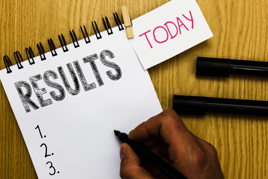 Writing note showing Results. Business photo showcasing Consequences outcomes produced by something Achievement development Man holding marker notebook clothepin reminder wooden table cup coffee.